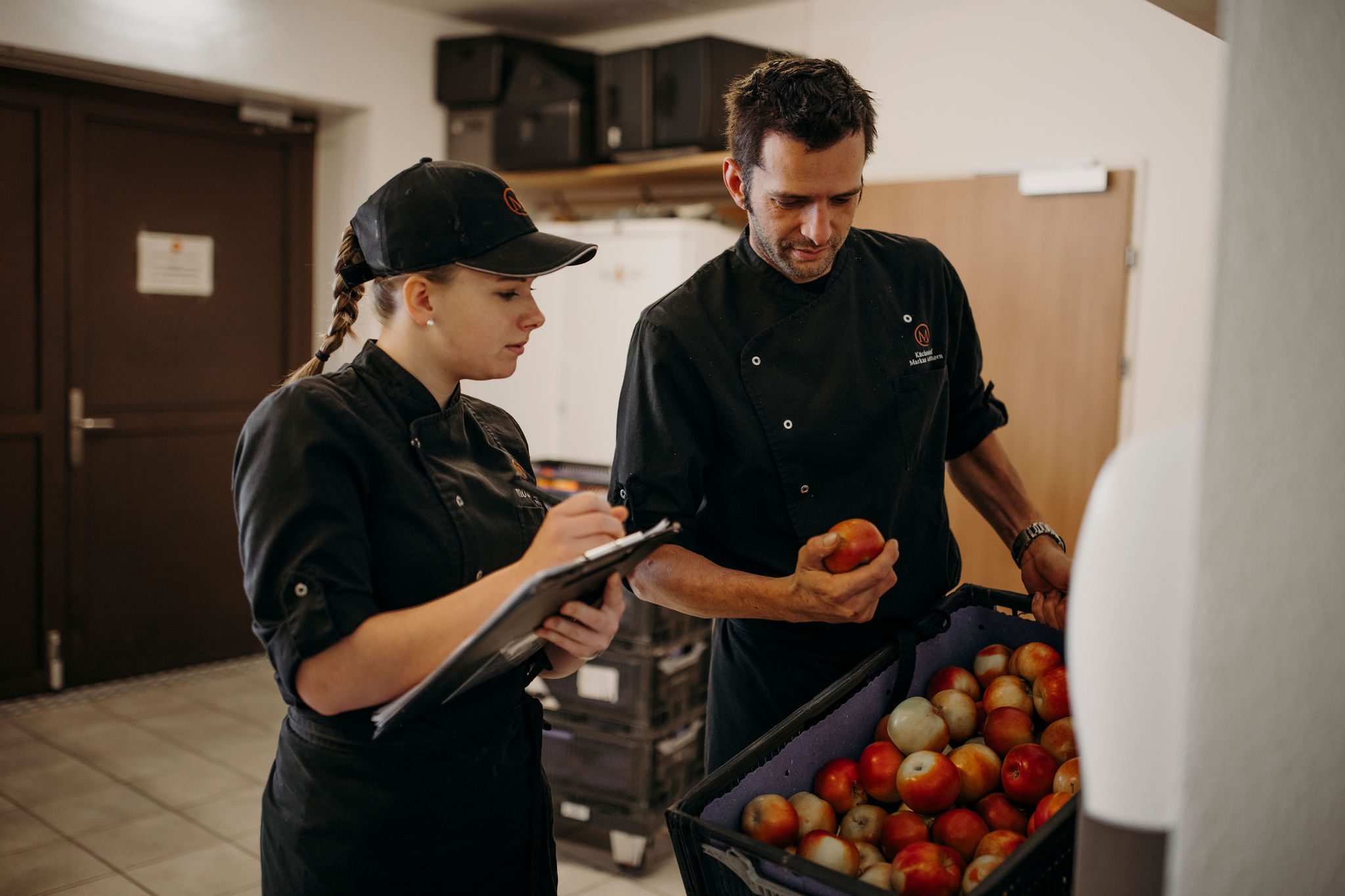 Kochlehrling und Ausbilder überprüfen die Menge und Qualität der angelieferten Äpfel